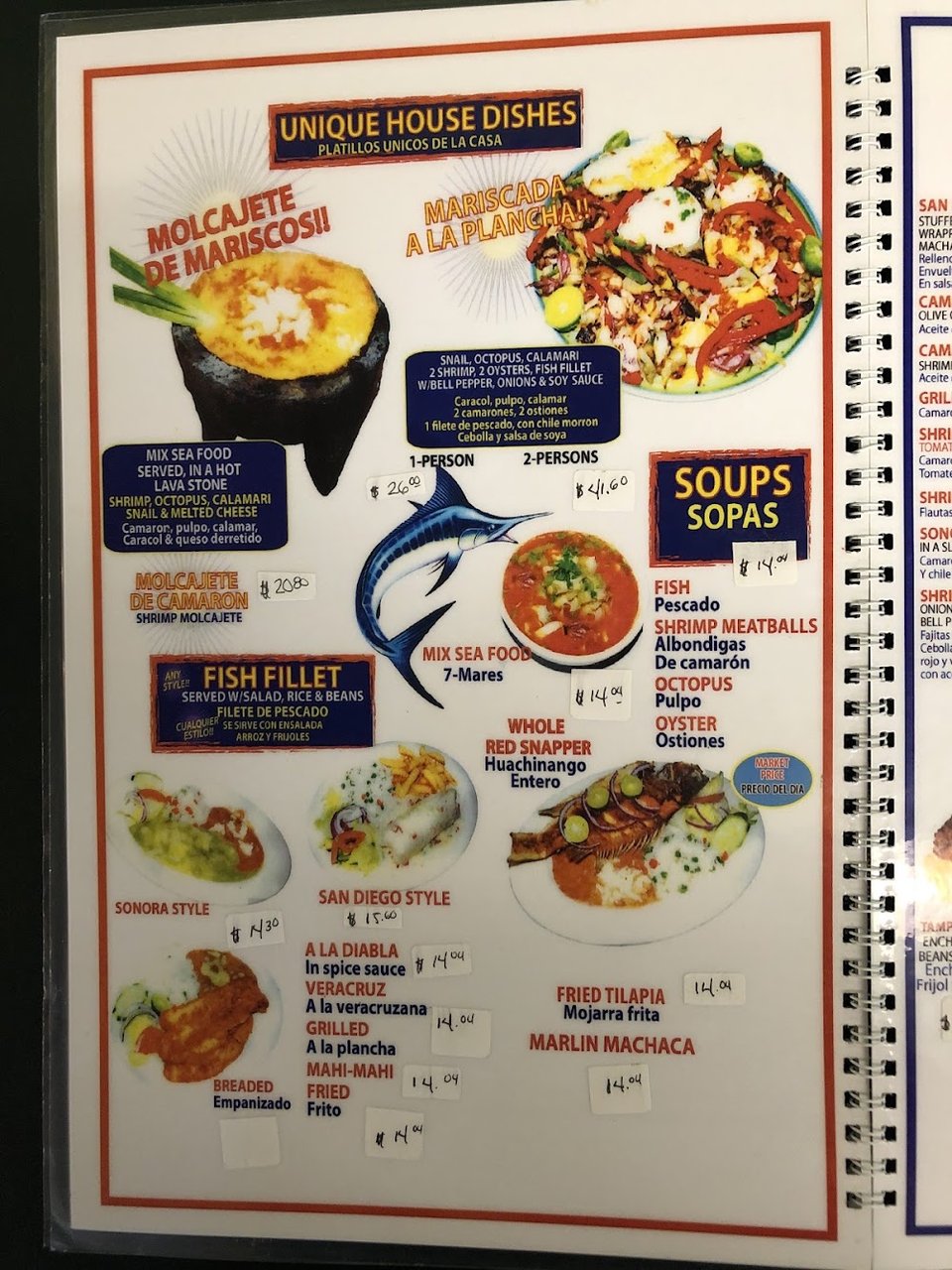 Close-up of a menu with seafood offerings.